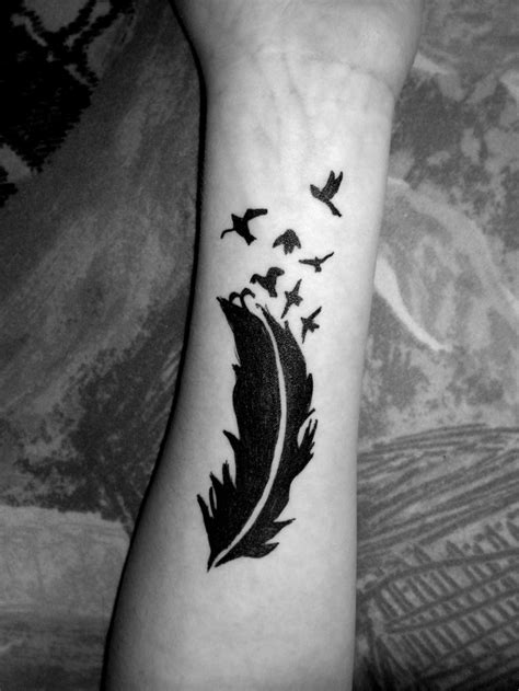 Little black feather bird tattoo on arm - Tattooimages.biz