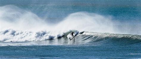 Surfer at Wainui Beach, north of Gisborne, on the East Coast of New ...