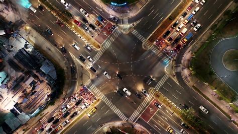 Aerial View - footage of vehicular traffic on a busy street intersection in the city at night ...