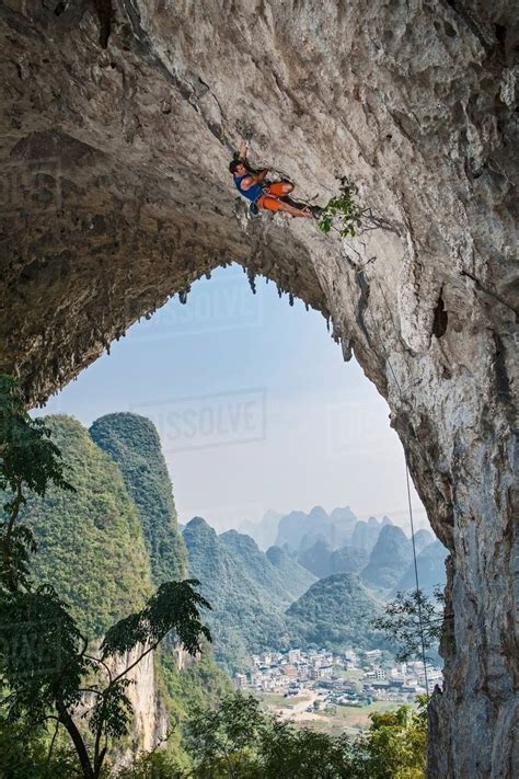 Male climber climbing the route Lunatic on Moon Hill in Yangshuo, Guangxi Zhuang, China - Stock ...