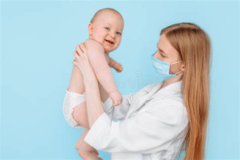 A Female Pediatrician in a Medical Mask with a Digital Infrared ...