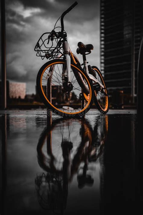 Vertical Low-angle Shot of a Cool Parked Bicycle on a Rainy Road with ...