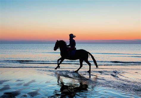 Silhouette of Horse and rider on Beach at sunset Photograph by Maggie Mccall