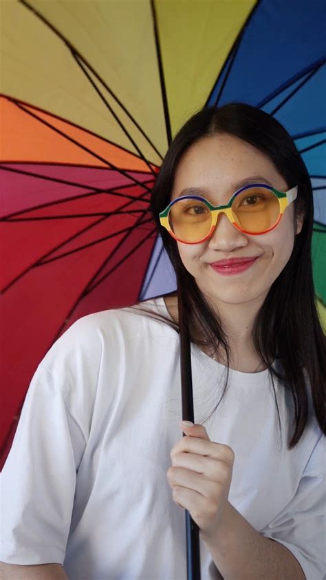 A Woman in Colorful Sunglasses Posing with a Rainbow Umbrella · Free Stock Video