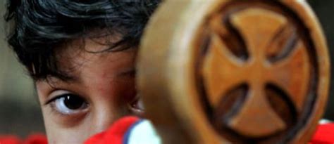 a young boy holding a wooden object up to his face