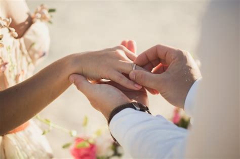 Premium Photo | Groom wears ring on bride's finger