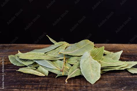 hojas de laurel seco sobre madera con fondo negro Stock Photo | Adobe Stock