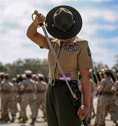 USMC Senior Drill Instructor Gunnery Sgt. Mayra Garcia returning her sword to her scabbard ...