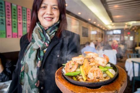 a woman standing in front of a plate of food on a wooden stand with ...