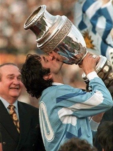 two men kissing each other while holding up a trophy in front of their ...