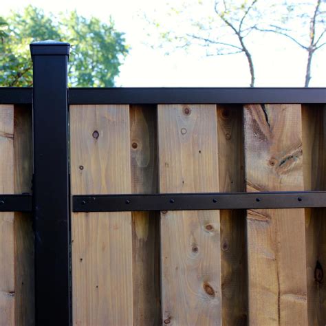 a wooden fence with black metal posts