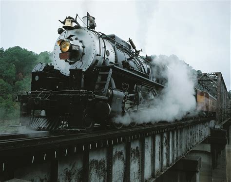 an old fashioned steam train traveling over a bridge