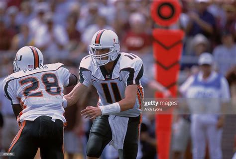 Ken Dorsey of the Miami Hurricanes hands the ball off to teammate ...