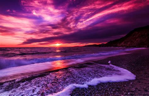 Download A Purple Sunset Over The Ocean With Waves Wallpaper ...