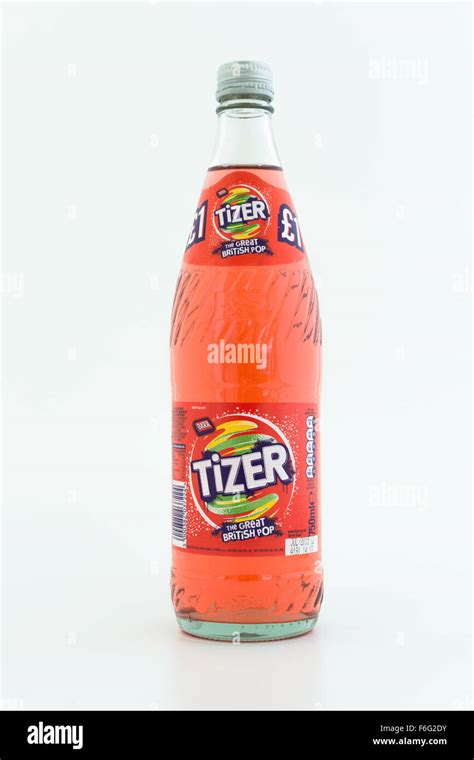 Glass returnable refund bottle of Tizer fizzy drink produced by A G Barr plc on a white ...