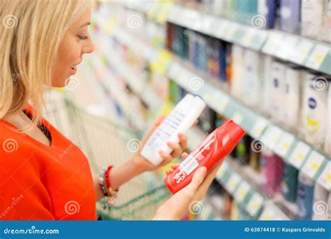 Woman In Supermarket Comparing Products Stock Photography ...