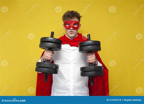 Superman with Super Strength and Superpowers Holds Heavy Dumbbells and Trains His Body on a ...