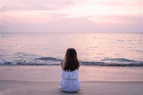 Premium Photo | Lonely young asian woman sitting on the beach at sunset