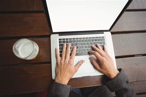 Overhead view of man using laptop in bar — working, refreshment - Stock Photo | #228986676