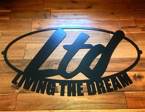 the logo for living the dream is shown on a wooden floor in front of a wood paneled wall