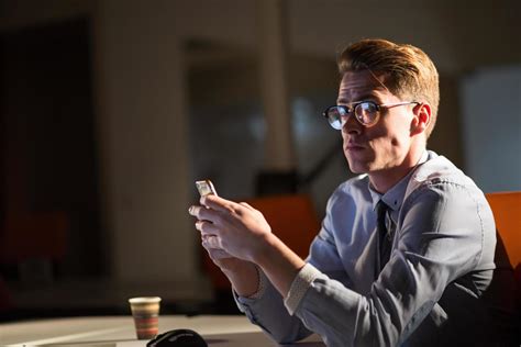 man using mobile phone in dark office 12441099 Stock Photo at Vecteezy