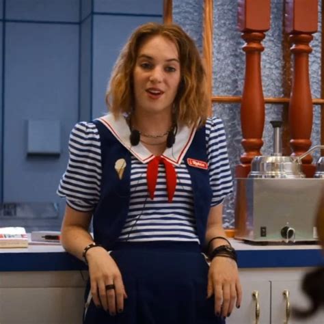 a woman sitting in front of a counter wearing a sailor outfit