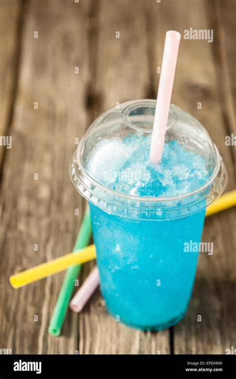 frozen blue slushie in plastic cup with straw Stock Photo - Alamy