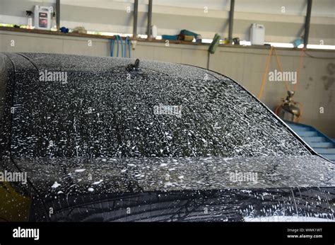 Wash the black car with foam at the car wash station Stock Photo - Alamy