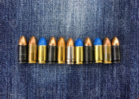 9mm pistol bullets on blue jeans, soft and selective focus, various ...