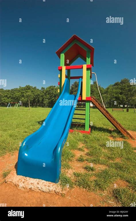 Blue slide at a children's playground in summer Stock Photo - Alamy