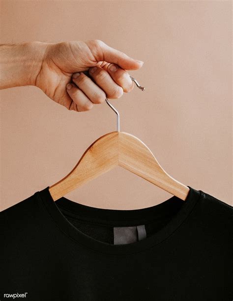 Download premium image of Hands holding a black t-shirt in a hanger 1235328 | Black tshirt ...