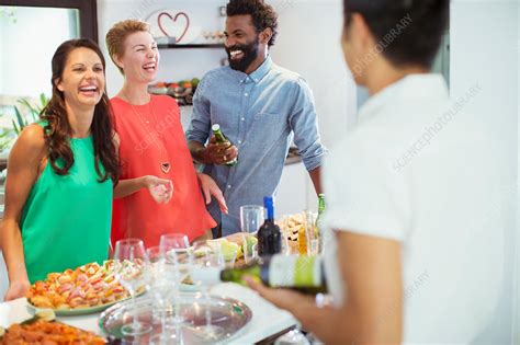 Friends laughing together at party - Stock Image - F014/7176 - Science Photo Library