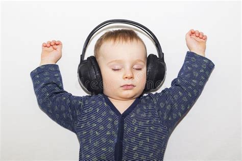 The Child Sleeps and Listens with Headphones Music. Sleeping Baby Stock ...