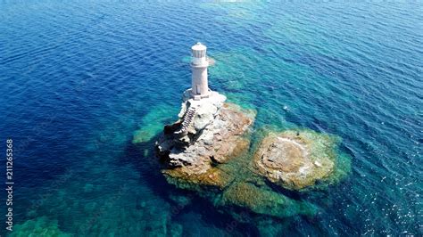 Aerial drone bird's eye view of iconic lighthouse of Tourlitis in port ...