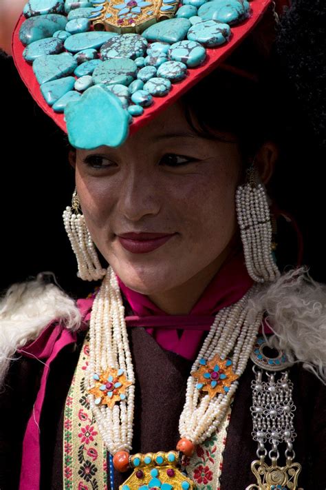 A beautiful Ladakhi lady wears a perak over her head, studded with ...