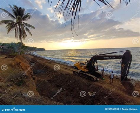 Excavator at Sea Wave Barrier Construction Project on Beach at Sunset ...