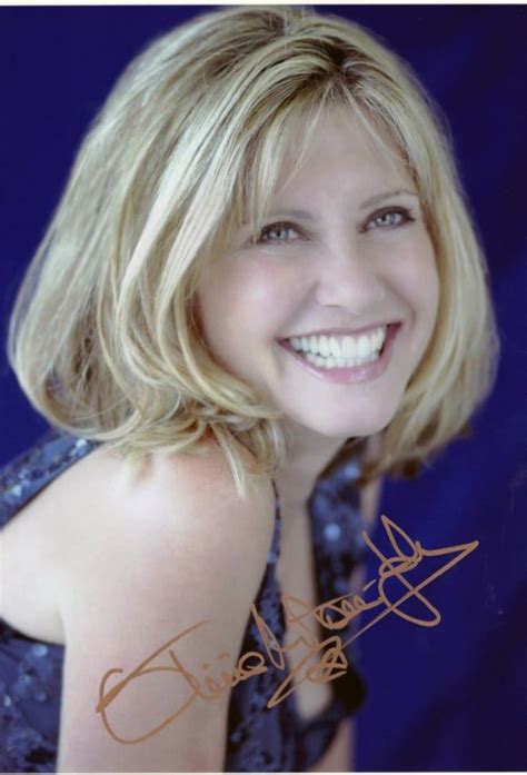 a woman with blonde hair smiling at the camera