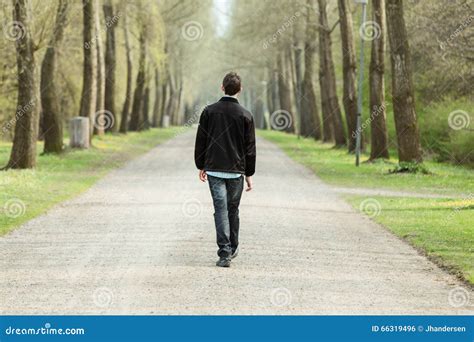 Teenage Boy Walking Down A Rural Road Stock Photo - Image: 66319496