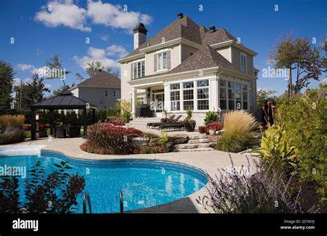 Upscale two-story home with landscaped backyard, patio furniture and in-ground swimming pool ...