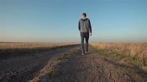 Young Man Walking Down Rural Road In Unique Stock Footage SBV-318691159 - Storyblocks