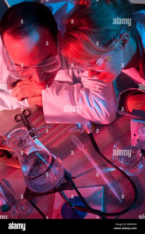 Woman and man in lab coats with lab equipment red and blue light Stock Photo - Alamy