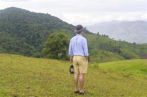 Traveling man enjoying and relaxing over beautiful green mountain view in rain season, Tropical ...