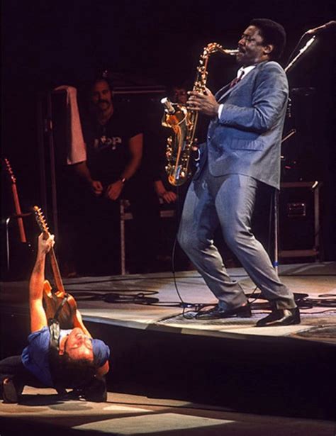 a man in a blue suit is playing the saxophone on stage with other ...