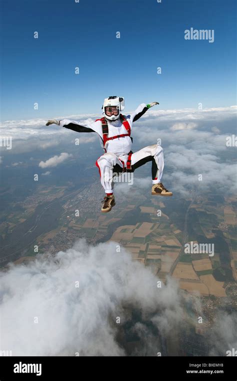 Man with camera on his helmet is filming skydiver in freefall over ...