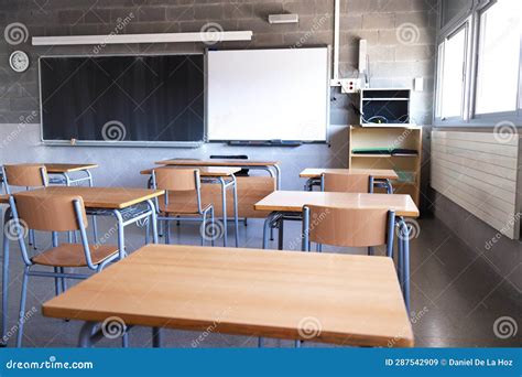 Empty High School Classroom with Natural Light. Wooden Desks and Chairs, Blackboard and ...