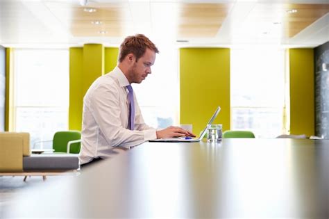 Premium Photo | Businessman using laptop in an office meeting area