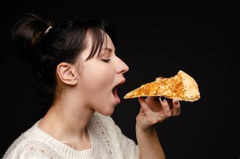 Premium Photo | Hungry girl with opened mouth eating pizza