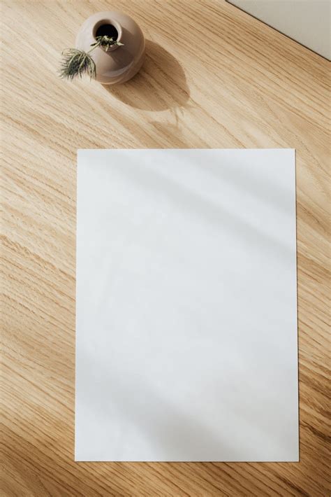 Blank white paper sheet on wooden table · Free Stock Photo