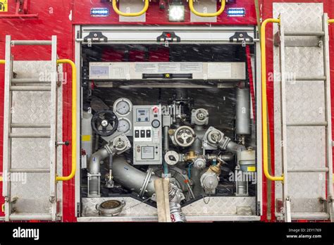 Fire truck equipment inside back vehicle. Open back side of red firetruck with water supply ...