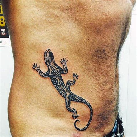 a lizard tattoo on the side of a man's stomach